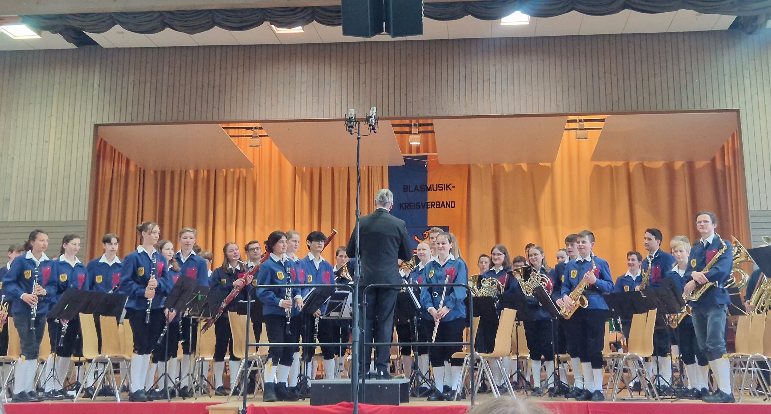 Bühne mit jungen MusikerInnen, sie halten Instrumente in der Hand. Jugendkapelle I Überlingen